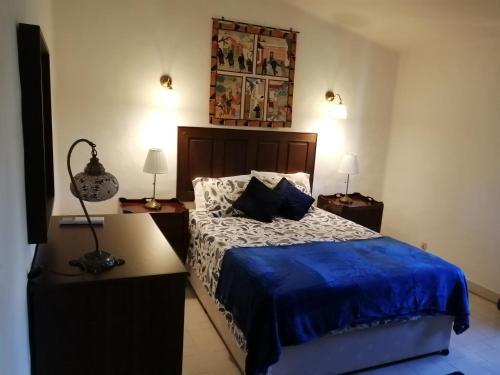 une chambre avec un lit recouvert d'une couette bleue dans l'établissement Villa Gwendolin, à Portimão