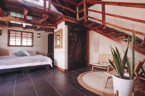 a bedroom with a bed and a potted plant at Sansara Surf Yoga & Resort in Cambutal