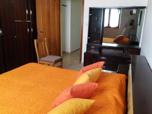 a bedroom with a bed with pillows and a television at Appartamento vicino al mare in Giardini Naxos