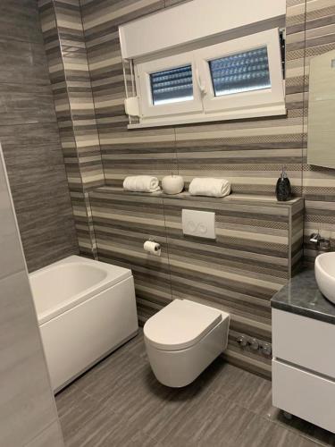 a bathroom with a white toilet and a sink at LUXURY VILLA HELENA in Kaštela