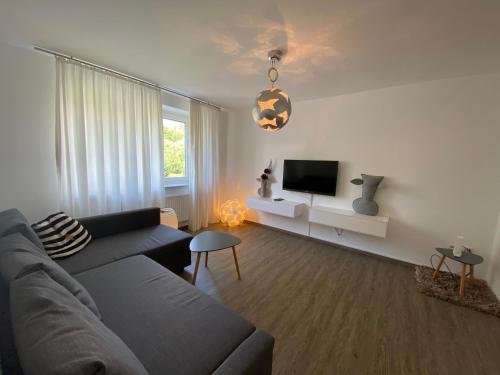 ein Wohnzimmer mit einem Sofa und einem TV in der Unterkunft Steinweg 7 Ferienwohnung in Kassel