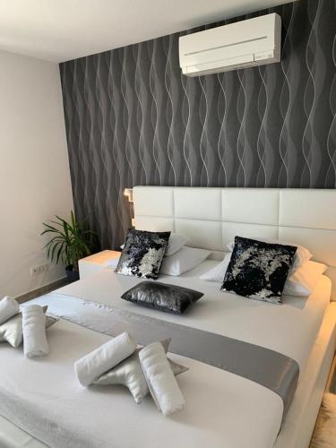 a white bed with pillows on it in a room at LUXURY VILLA HELENA in Kaštela