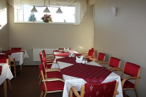 a dining room with tables and chairs and a window at Hotel Madona in Madona