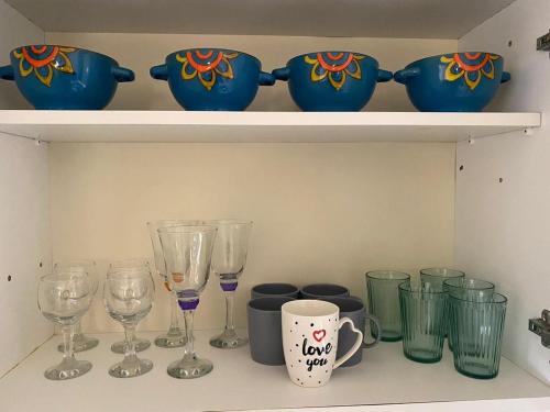 a shelf with wine glasses and vases on it at Comfort Apartment in Larnaka