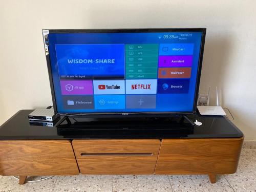 a television sitting on top of a wooden dresser at Comfort Apartment in Larnaka