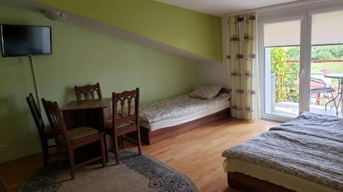 Schlafzimmer mit einem Schreibtisch, einem Bett und einem Fenster in der Unterkunft Willa Wega in Sianożęty