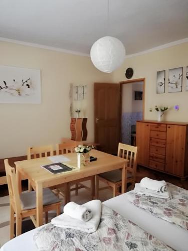 毛科的住宿－Csilla Apartman，一间带桌子和两张床的用餐室