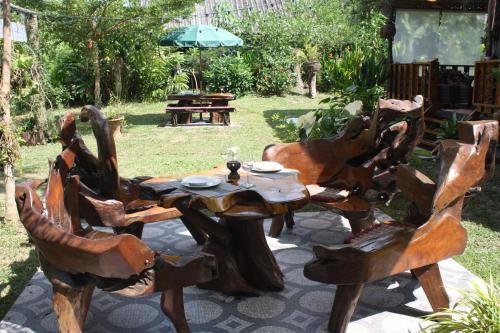 a group of wooden chairs around a wooden table at Kuba Bungalows in Ko Kood