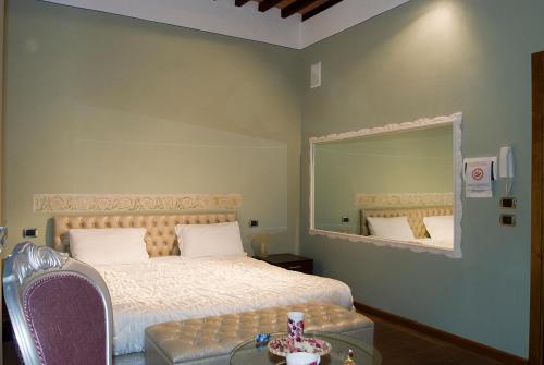 a bedroom with a bed and a mirror and a table at Vicolo dell'Oste in Montepulciano