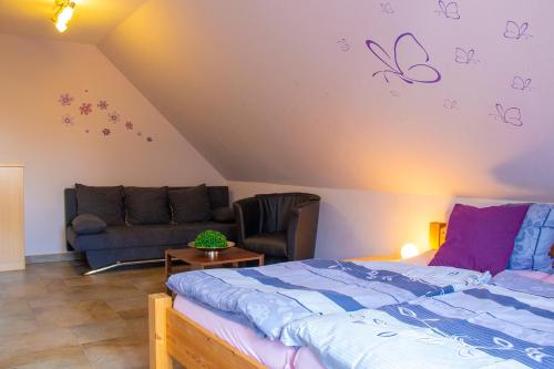 een slaapkamer met een bed en een bank bij Ferienhaus Nienhagen - Jule in Ostseebad Nienhagen