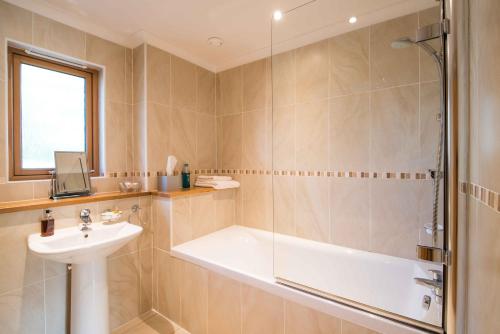 a bathroom with a bath tub and a sink at The Redgarth in Oldmeldrum