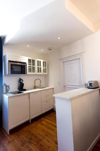 a kitchen with white cabinets and a counter top at L'échappée in Bourges
