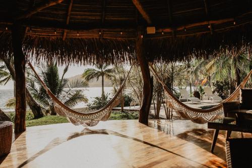 a patio with hammocks and a table and chairs at Sansara Surf Yoga & Resort in Cambutal