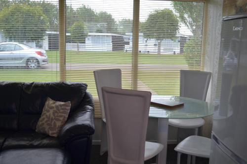 a living room with a table and chairs and a couch at Chalet 66 in Skegness