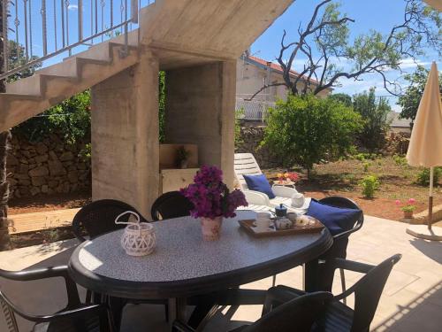 - une table avec un vase de fleurs sur la terrasse dans l'établissement Apartment Ilovik 154 - 3 bedroom, à Ilovik