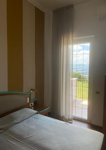 a bedroom with a bed and a sliding glass door at Hotel ristorante Bellavista in Colonnella