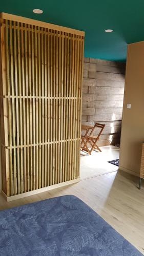 a room with a wooden partition with a table and chairs at Le lodge origin in Sainte-Suzanne