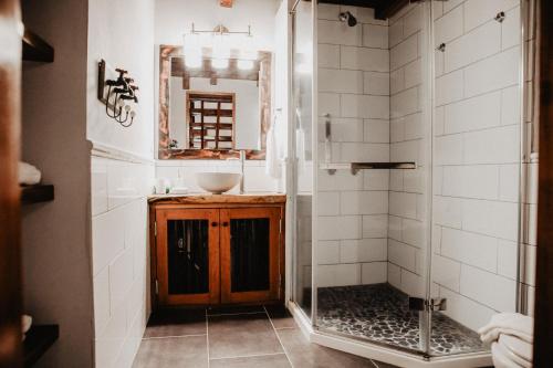 a bathroom with a shower and a sink and a mirror at Sansara Surf Yoga & Resort in Cambutal