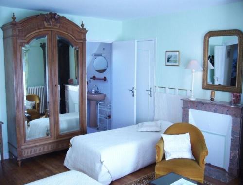 een slaapkamer met een groot bed en een spiegel bij Ferme de Dauval in Mandeville-en-Bessin