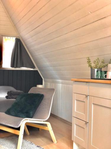a room with a bed and a chair in a attic at Camping Milk in Usmenieki