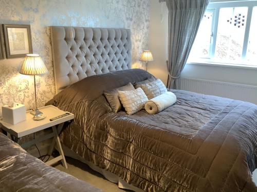a bedroom with a large bed and a table with lamps at Birtles Farm Bed and Breakfast in Knutsford