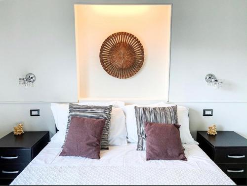 een slaapkamer met een wit bed en 2 nachtkastjes bij Taonasi Mazzarò Apartments in Taormina