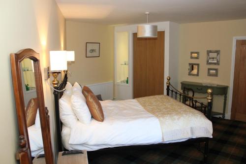 a bedroom with a bed and a mirror at The Marine in Thurso