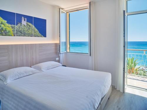 a bedroom with a bed with a view of the ocean at Hotel Medusa in Finale Ligure