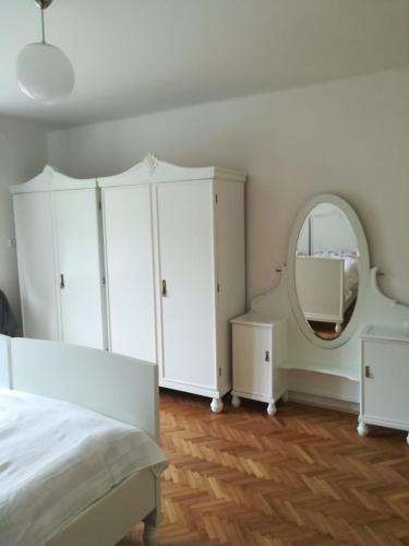 a bedroom with a white cabinet and a mirror at Dům u splavu in Karolinka