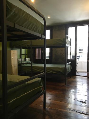 a room with three bunk beds and a wooden floor at Albergue Azabache in Santiago de Compostela