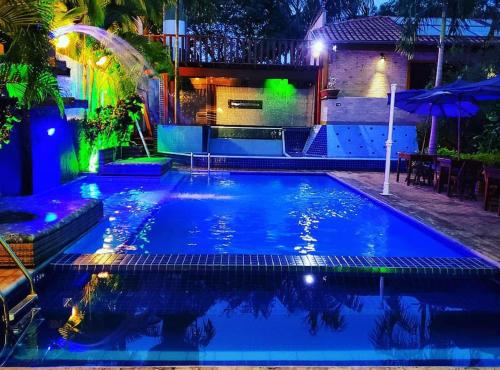 a swimming pool in a backyard at night at Hotel Natural - SPA & Lazer in Brotas