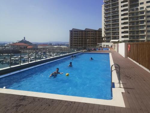 eine Gruppe von Personen in einem Schwimmbad in einem Gebäude in der Unterkunft NEW - Kings Wharf Quay29 - Large Studio Apartment with 3 Pools - Gym - Rock Views - Holiday and Short Let Apartments in Gibraltar in Gibraltar