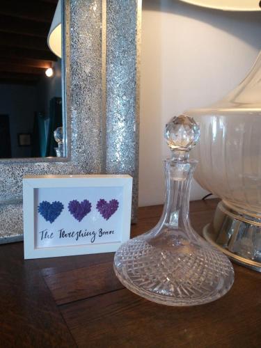 a glass bottle sitting on a table next to a mirror at The Threshing Barn in Harrogate