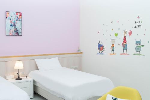 a white bedroom with a bed and a chair at 菓香101民宿fruity101 in Shoufeng