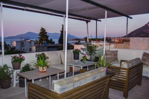 a patio with tables and chairs on a roof at Ronzi Apartments in Kamena Vourla