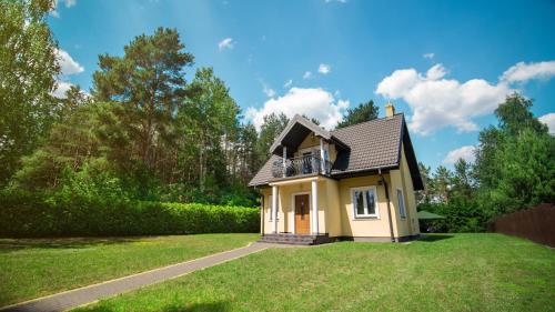 アウグストゥフにあるPełny Relaks - Sajenekの緑の芝生の小さな黄色い家