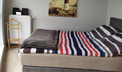 a couch with a striped blanket on top of it at Horyzont 806 in Międzyzdroje