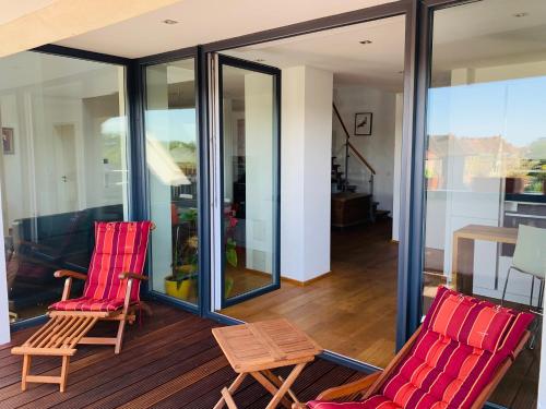 two red chairs and a table on a balcony at Exklusives Penthouse im ehemaligen Bunker in Hannover