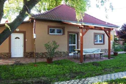 a small house with a bench in the yard at Tessedik Vendégház in Hajdúszoboszló