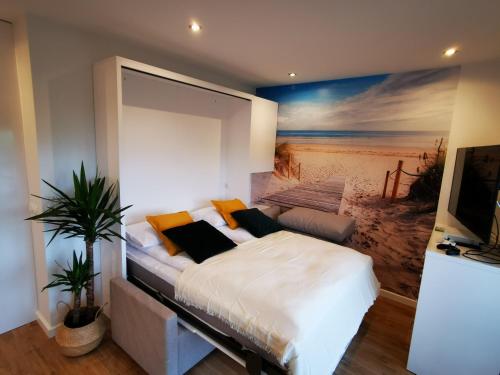a bedroom with a bed with a painting on the wall at M&K Apartamenty Deluxe Gdańsk Sobieszewo 1 in Gdańsk