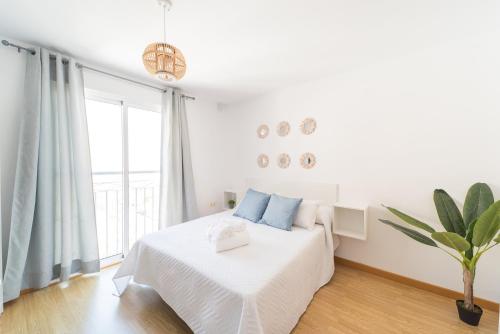 a bedroom with a white bed and white walls at Apartamentos Puerto Aguadulce in Aguadulce
