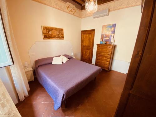 a small bedroom with a bed and a dresser at Casa Teatro in Cortona