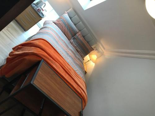 a bedroom with a bed with an orange blanket on it at Pisgah Guesthouse Snowdonia in Blaenau-Ffestiniog