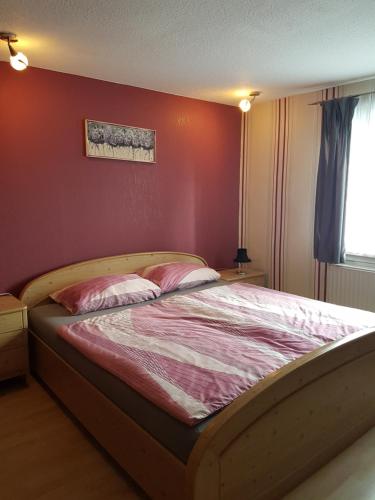 a bed in a bedroom with a red wall at Gasthaus Goldner Löwe in Friesau