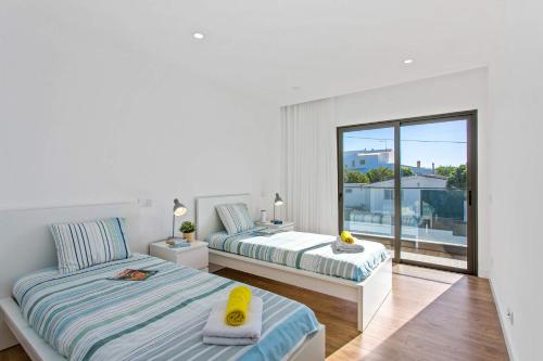 een slaapkamer met twee bedden en een balkon bij Villa Ohana in Albufeira