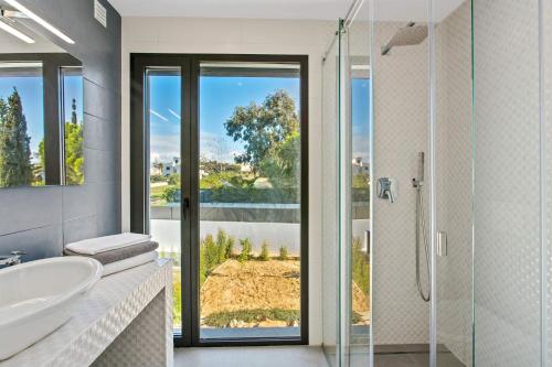 een badkamer met een bad, een wastafel en een douche bij Villa Ohana in Albufeira