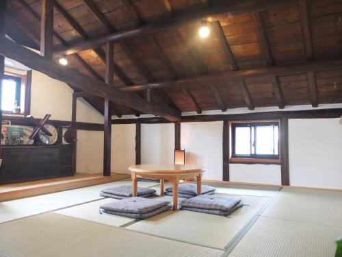 常滑市にあるYOMOGI GUESTHOUSEのテーブルと窓のあるダイニングルーム