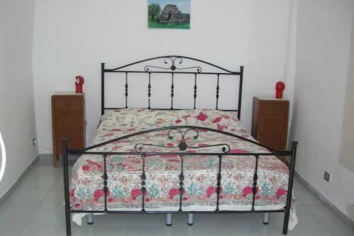 appartamentino in villa antica في مارينا سيرا: غرفة نوم مع سرير مع لحاف متهالك