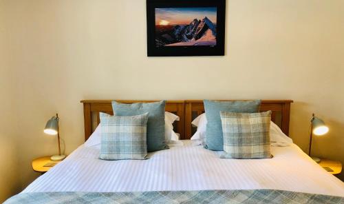 a bedroom with a bed with blue and white pillows at Kilmuir Park in Dunvegan