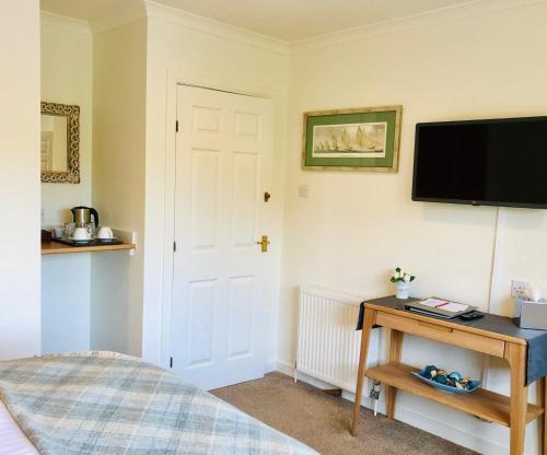 a bedroom with a bed and a television on a wall at Kilmuir Park in Dunvegan